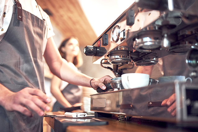 Kahvilan työntekijä valmistaa kahvia